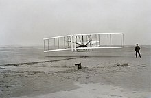 First flight of the Wright Flyer I, December 17, 1903, Orville piloting, Wilbur running at wingtip. First flight2.jpg