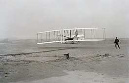 De Amerikaan Orville Wright makket yn 1903 op it strân fan Noard-Karolina de earste flecht yn in fleanmasine.