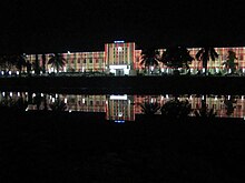 Освещенное здание ночью, отражение в воде