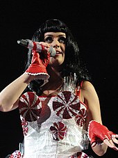 Perry performing with a dress decorated with peppermint swirls