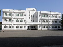 White, rectangular building with many windows