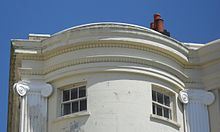 102 Marine Parade has such Regency-style features as a bow-fronted stuccoed facade, fluted Ionic pilasters, decorative capitals and a parapet. Parapet and Cornice at 102 Marine Parade, Brighton.JPG