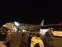 People waiting on airport tarmac for flights after aftershocks forced the airport to open all exit doors Qatar Airways Cargo B777 providing humanitarian support after the 2015 Nepal earthquake April 26, 2015.JPG