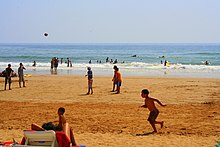 Photograph of people on a beach.