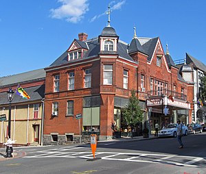 An ornate brick building with several capped towers. A marquee on the front has large lettering that reads "Music Hall"