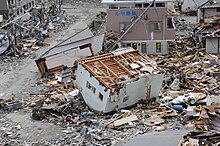 Umgestürztes Haus; Quelle: US Navy/Wikimedia