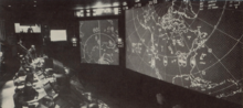 The "war room" of the Chidlaw Building's Combined Operations Center took over command center operations in 1963 from the nearby Ent AFB "main battle control center" (screens show missile impact ellipses for an exercise.) 1964 Chidlaw Building war room.png