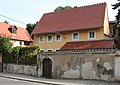 Bauernhaus (ehem.) mit Einfriedung, Stützmauer und kleinem Torbogen