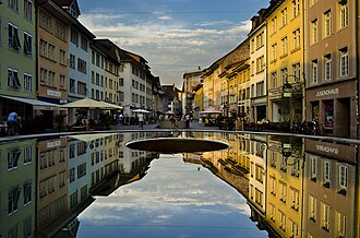 Spiegelung der Steinberggasse im westlichen Brunnenbecken.