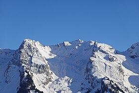 La tête Pelouse (au centre) avec à sa droite le mont Rachais et son aiguille dominant la combe du Grand Crêt (au centre) la séparant de la roche Perfia (à gauche).