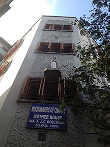 Трехэтажное здание с вывеской и статуей