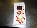 A dessert of Panna Cotta, infused with orange, with a chocolate and walnut brownie and raspberry sauce