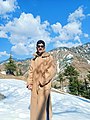 A young man wearing a fitted, fur-collared, fashionable Pheran in Chenab Valley's Bhaderwah