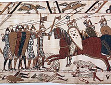 Détail d'une tapisserie montrant à gauche des hommes à pied en armes et à droite des cavaliers brandissant des lances