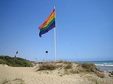 The rainbow flag flies in Capocotta, near Rome, Lazio, a gay-friendly beach on the Italian Mediterranean Sea Capocotta gay beach.jpg