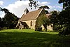 A small simple church seen from the southeast, with a south porch and a bellcote with a pyramidal roof at the west