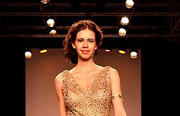 Koechlin walking the ramp in gold dress.