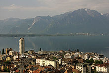 Looking past a city towards a lake, with mountains behind