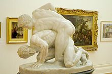 Sculpture de deux hommes nus en position de lutte.