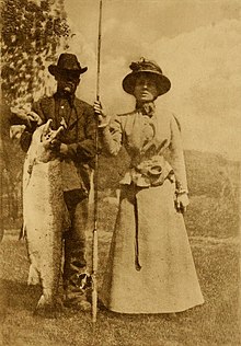 old photo of lady fly fisher with salmon