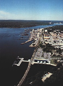 Basens sigill och flygfoto över området från 1990 med Submarine Force Library and Museum och museifartyget USS Nautilus i förgrunden.
