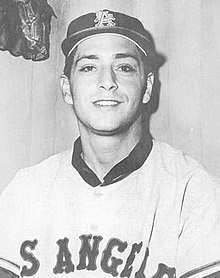 A man in a light baseball uniform and dark cap