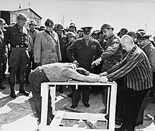 Survivors of the Ohrdruf concentration camp demonstrate torture methods used in the camp. Buchenwald Eisenhower torture demonstration 63511.jpg