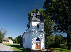 Kaplička na návsi, v pozadí rybník