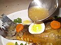 Bouillon de poisson versé sur un poisson cuit (Gefilte fish, plat typique juif de l'Europe de l'Est).