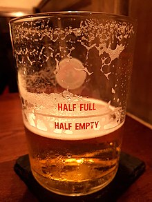 A beer glass made by Camden Town Brewery (London). The physical presence of beer in the glass's lower part, exactly where the inscription is: 'HALF EMPTY', sets a collision between two frames of reference. This incongruity results in a humorous effect at the moment of its realization. HalfFullHalfEmptyBeerGlass.jpg