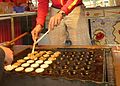 Wenden der Poffertjes nach der Hälfte der Backzeit