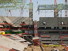 A freak storm on the evening of 4 January 2009 blew over a construction tower crane which crashed through the partially completed roof structure and the concrete setaing terraces structures. This is the internal view. Mbombela Stadium crane crash int.jpg