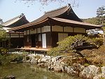 A single-storied wooden building with a hip-and-gable roof, white walls and wooden sliding doors.