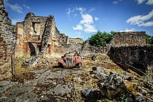 Photo en couleur de maisons en ruine et d'une carcasse de voiture rouillée