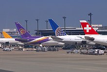 Aircraft of various airlines parked side by side at Tokyo Narita Airport, Japan 011 Aircraft of various airlines together at Narita Airport, Japan. Swiss Air Lines, United Airlines, Thai Airways.JPG