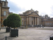 Vue de la façade d'un palais aux colonnes doriques.