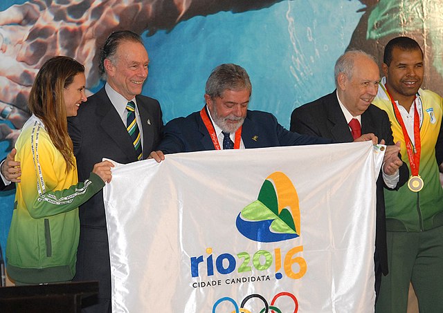 Presidente Lula posa com a bandeira da candidatura em encontro com atletas.