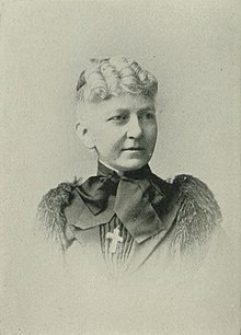 19th-century B&W portrait photo of a woman with her white hair in an up-do, wearing a dark blouse