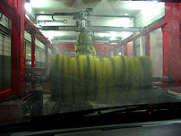 Rotating brushes inside a conveyor car-wash.