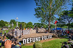 A "defund police" sign and stage before a rally at Powderhorn Park in Minneapolis, June 7, 2020 Minneapolis City Council Pledges to Dismantle Police Department.jpg