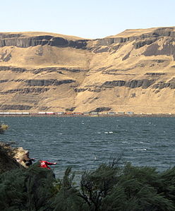 Die Horse Heaven Hills entlang des Columbia River an der Wallula Gap; bemerkenswert sind die dunklen Bereiche aus Basalten, die von der Erosion zutage gebracht wurden.