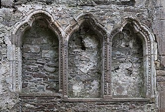 Photographie de trois niches décorées de motifs sculptés.