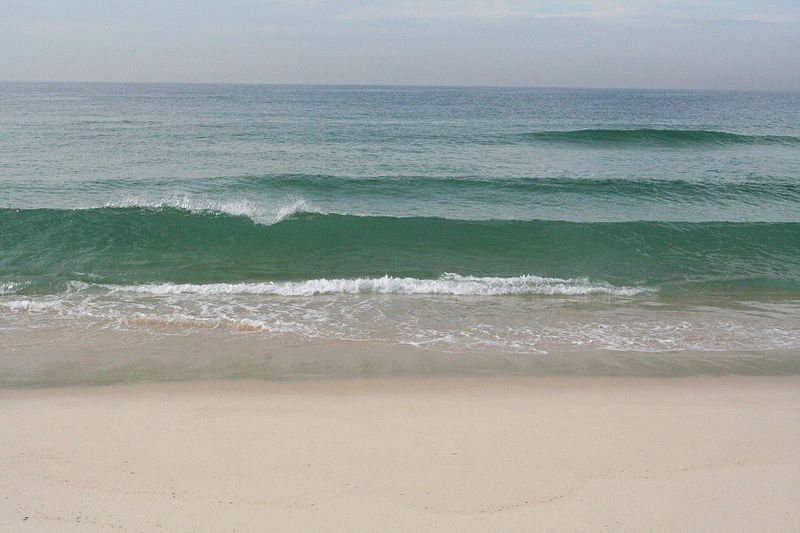 File:Gentle waves come in at a sandy beach.JPG