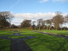 View of formal paths, green grass and trees in the distance