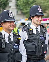 Metropolitan Police officers in 2019. The custodian helmet has been called "an iconic symbol of British policing". Pride London 39.jpg