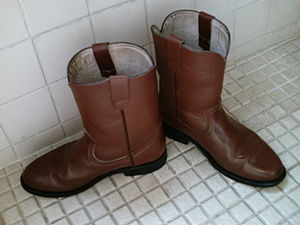 A pair of roper-style cowboy boots. Notice the...