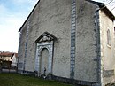 L'ancienne entrée de l'église avec une stèle d'une tombe