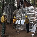 Resource Advisors (READ) from the National Park Service apply fire-resistant wrap to a historic Bildeo cabin.[23]