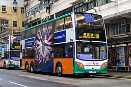 A picture of a passenger bus in traffic depicting a poster of a big-eared elephant