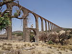 Высокий арочный акведук в засушливом ландшафте